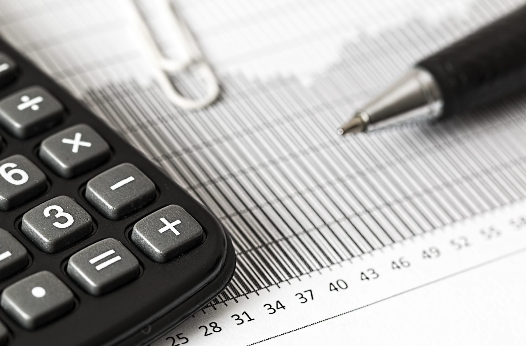 Image of a calculator, pen and printed numbers to begin Lindsay Smith's real estate blog about using statistical information to understand real estate numbers