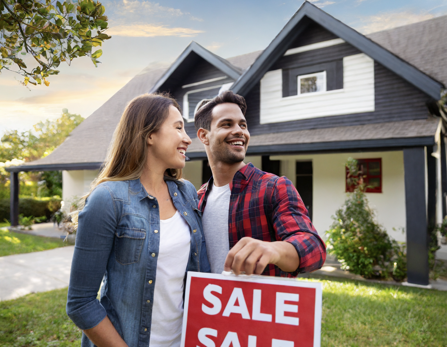 Young couple standing in front of a home that is for sale. Featured image for a blog by Lindsay Smith, Buy Sell Love Durham about what you need to know about making an offer on a power-of-sale home.